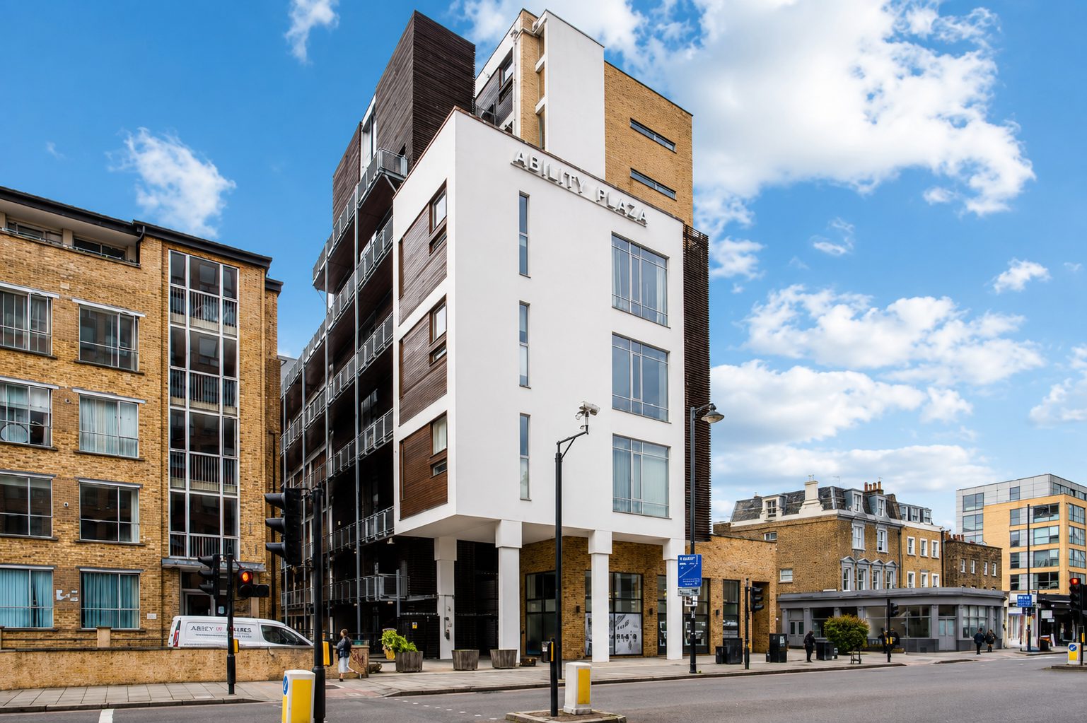 Ability Plaza on the corner of Kingsland Road and Arbutus Street, Haggerston, its upper storeys finished in dark rainscreen cladding above white render