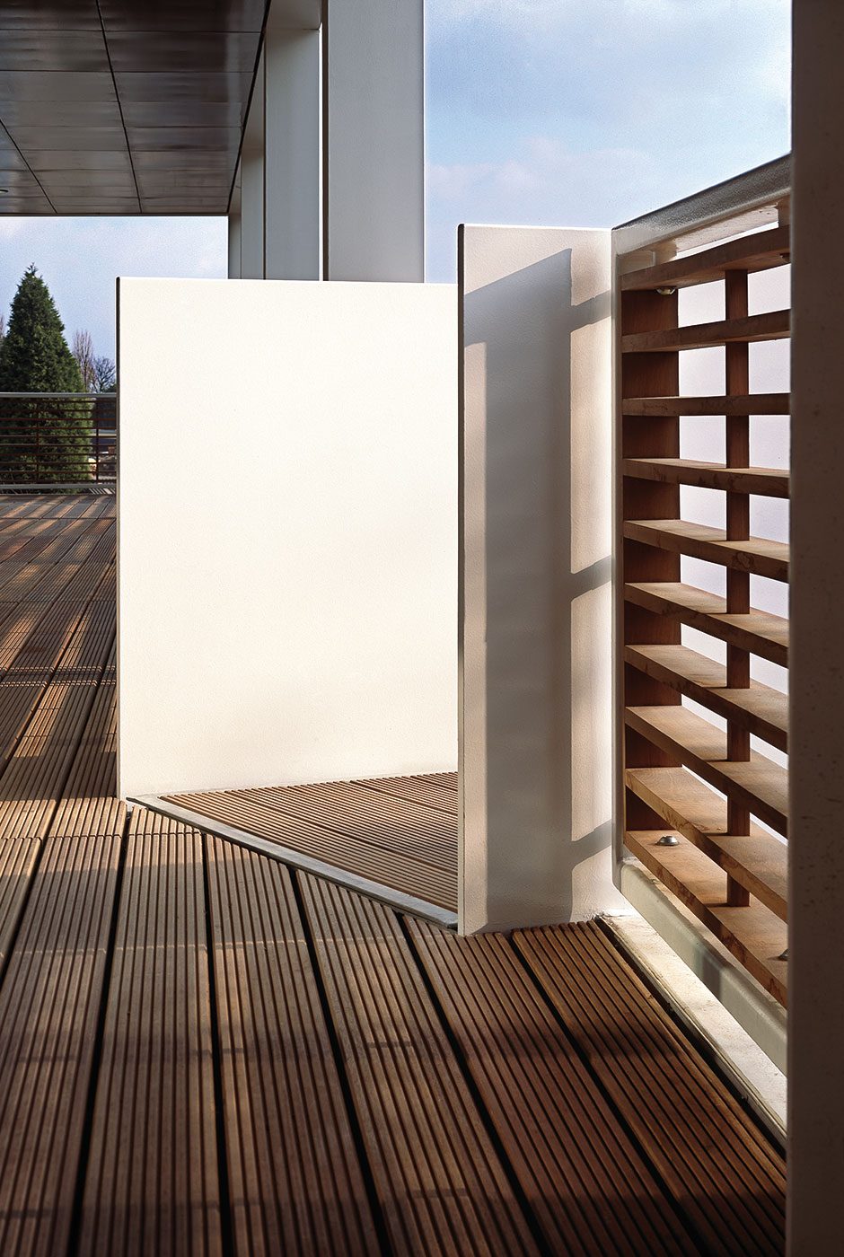 A white-clad wall meeting a timber slatted screen on the roof terrace of Ashfield House's rooftop pavilion