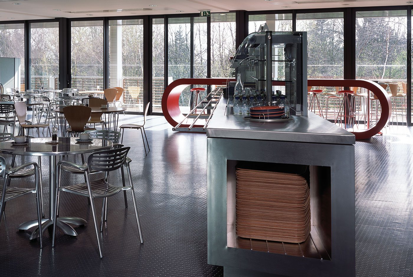 The café and restaurant space inside Ashfield House's rooftop pavilion, with steel-framed servery counters and floor-to-ceiling glazing