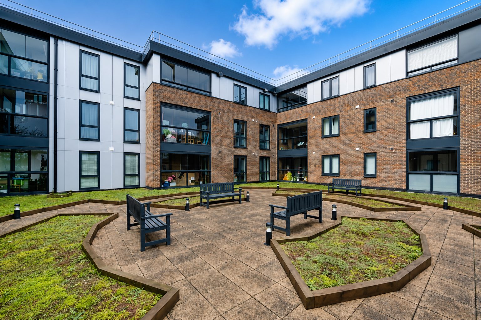 Bishopsgate House's landscaped courtyard, brick and pale grey cladding around three storeys of glazed homes