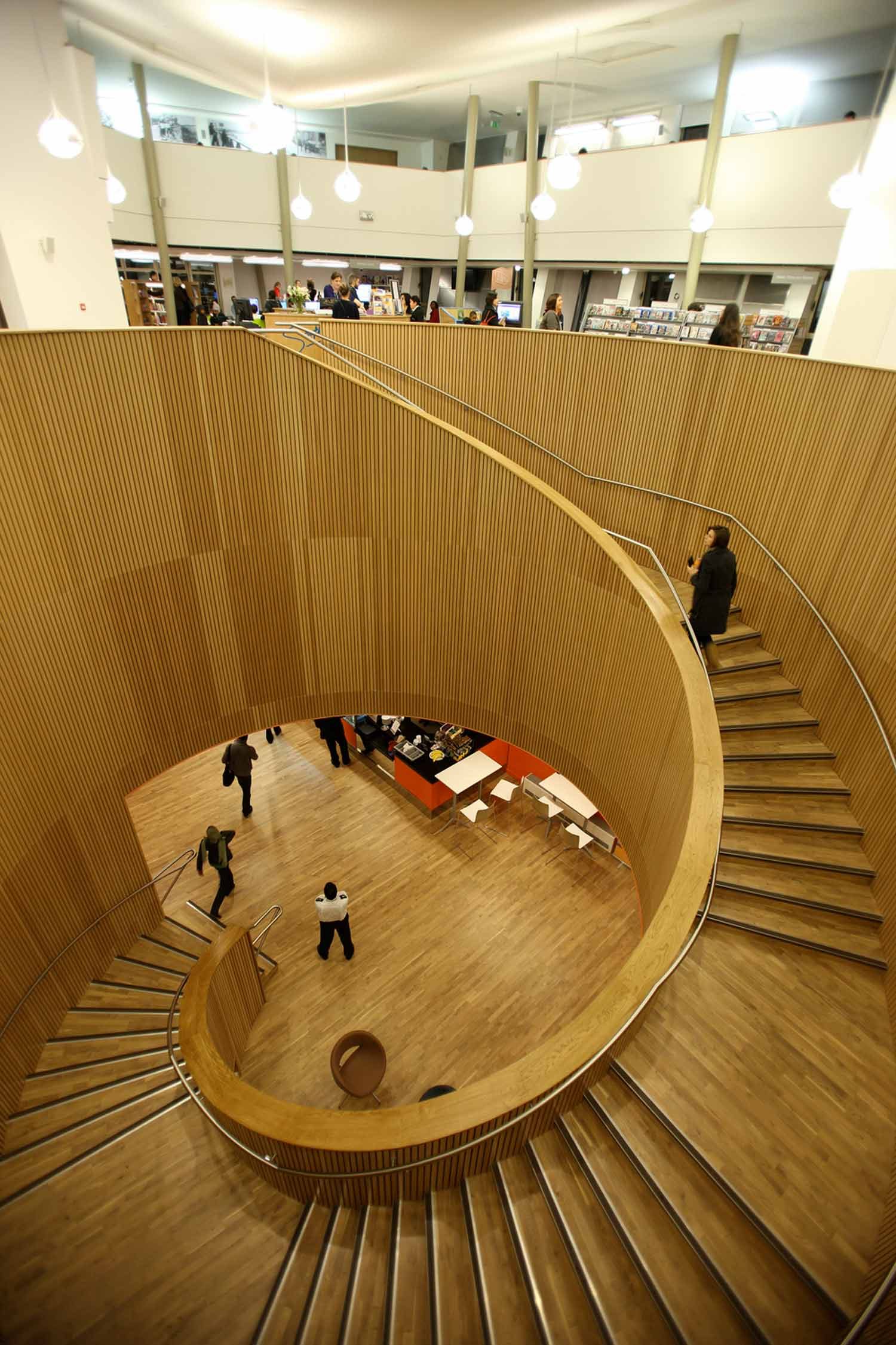 Canada Water Library's helical stair, its walls lined with vertical oak ribs, seen from below