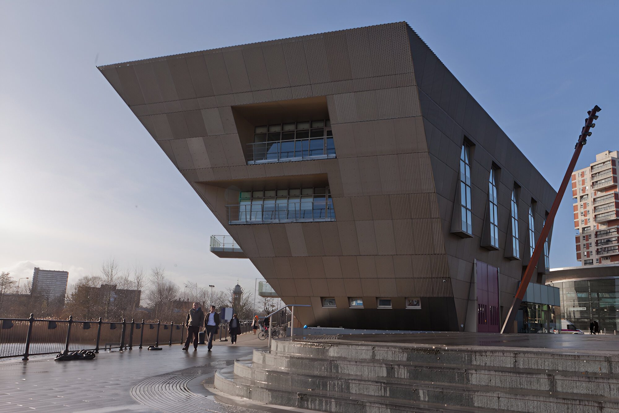 Canada Water Library seen in daylight, the cantilevered clad form overhanging Deal Porters Square