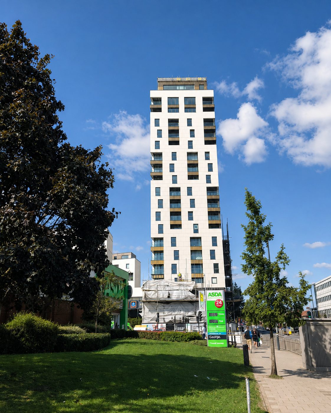 Everly House tower nearing completion, seen across a green space in Colindale with protective wrap still on its lower floors
