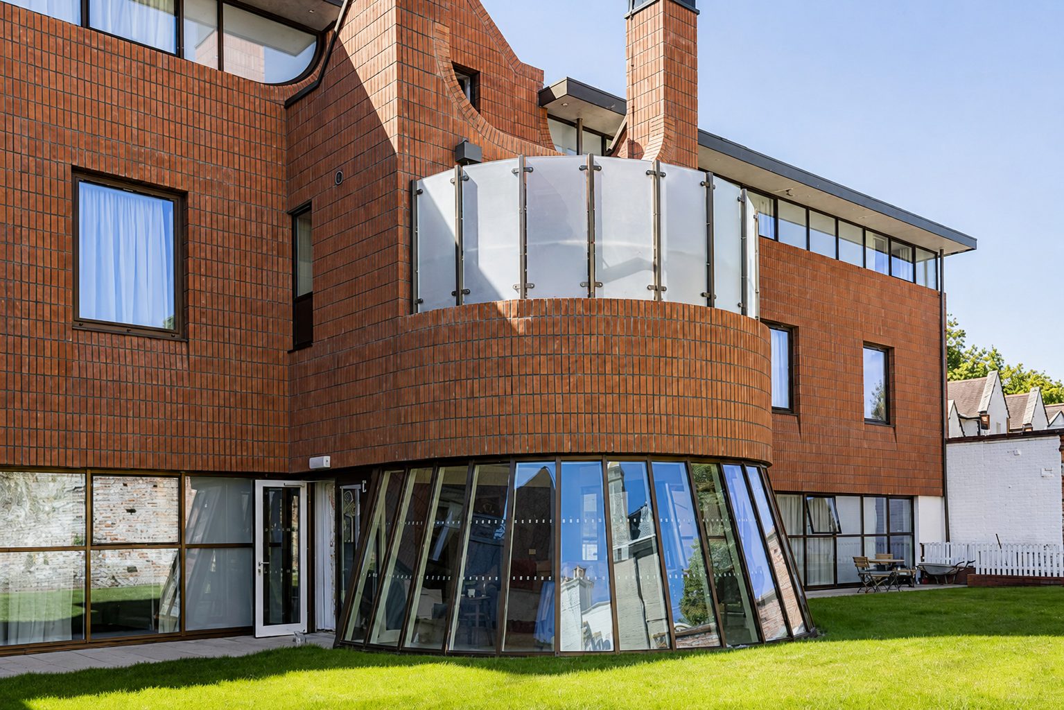 Garden elevation of the Mount Ephraim House development, showing a curved brick bay with a roof terrace above a glazed link room