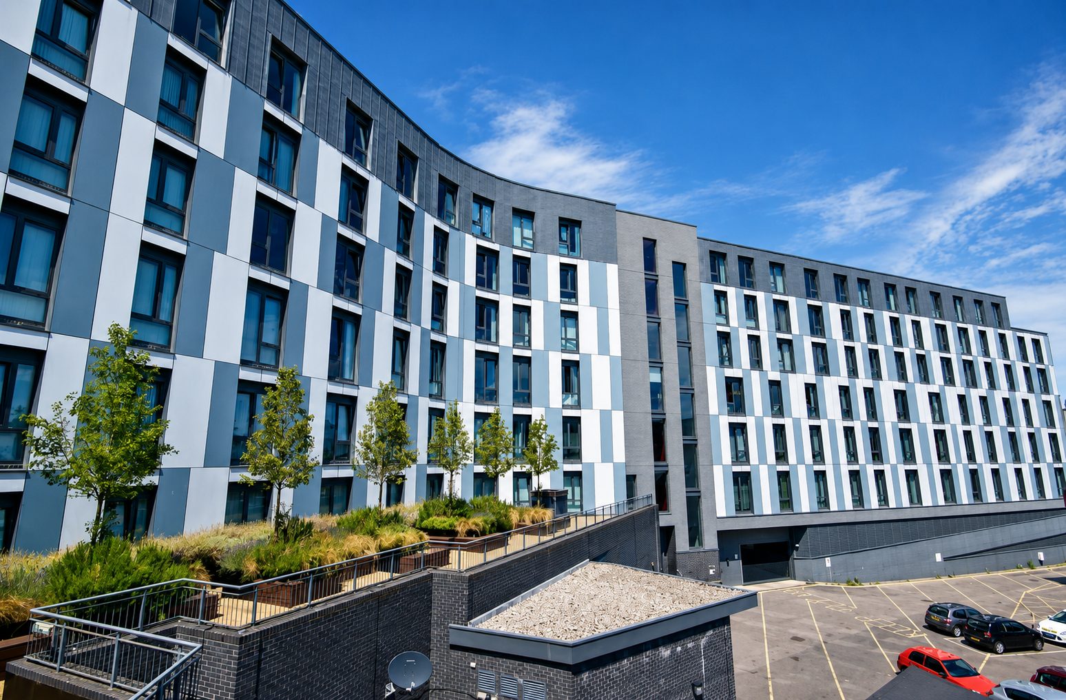 Nobel House's landscaped roof terrace with young trees, overlooking the building's car park in Redhill