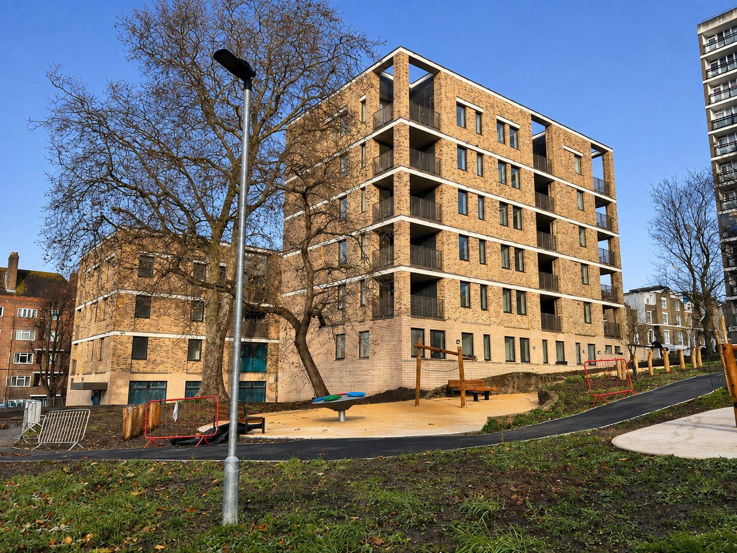 Rye Hill Park's brick block beside its new playground and retained mature tree, seen in winter