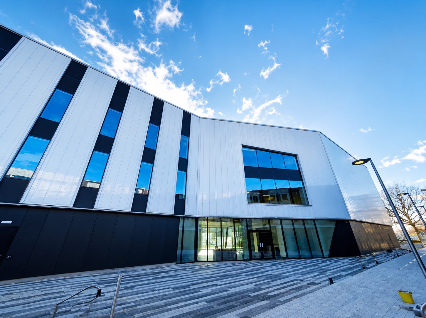 The completed Centre for Digital Technologies exterior, its vertical ribbed cladding panels and full-height glazing at the entrance canopy