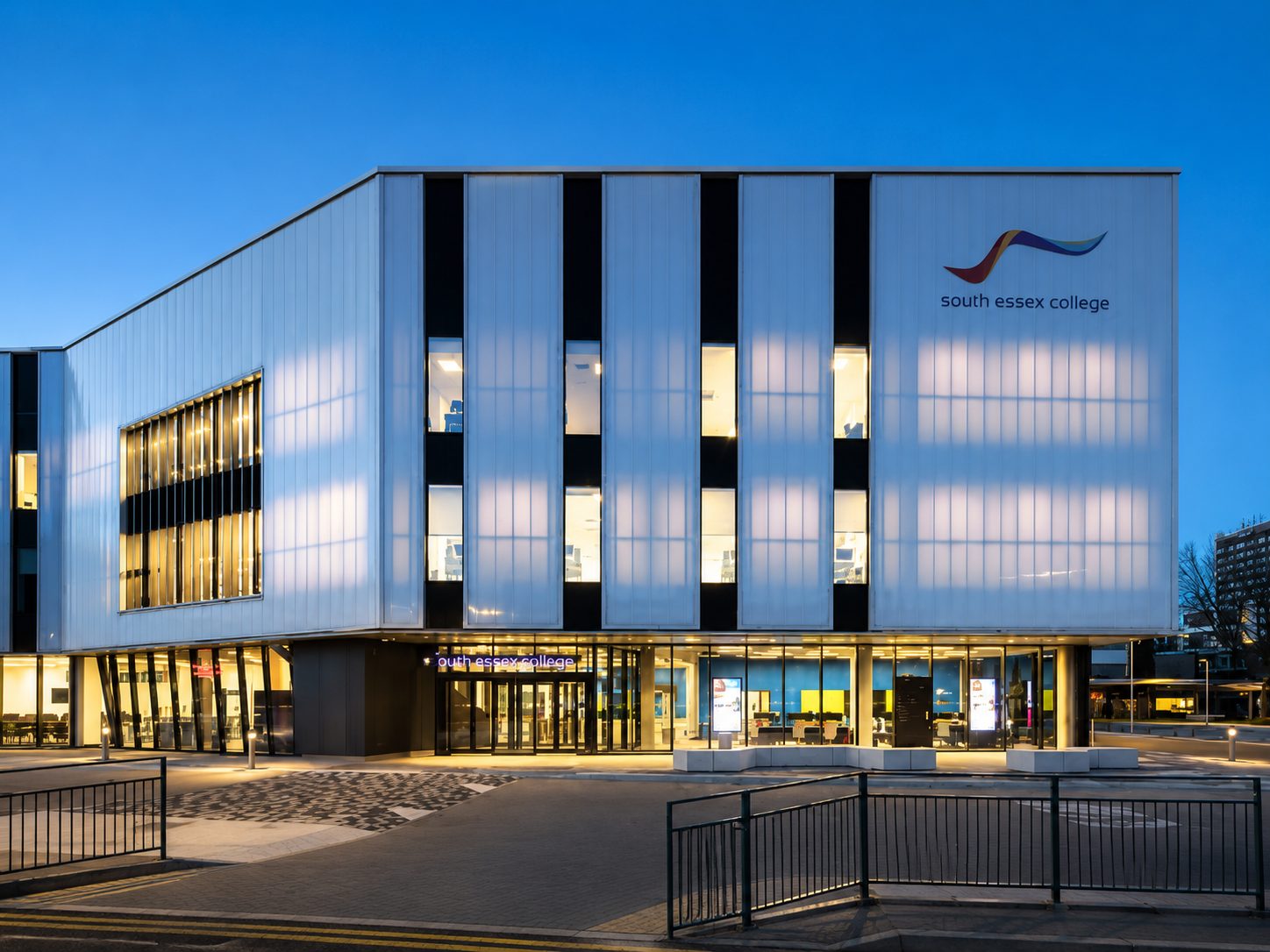 South Essex College's Centre for Digital Technologies at dusk, its illuminated entrance and signage lit against the twilight sky