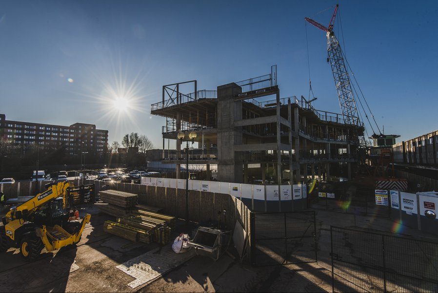 The Centre for Digital Technologies' concrete and steel frame under construction, with a tower crane above and site cabins in the foreground