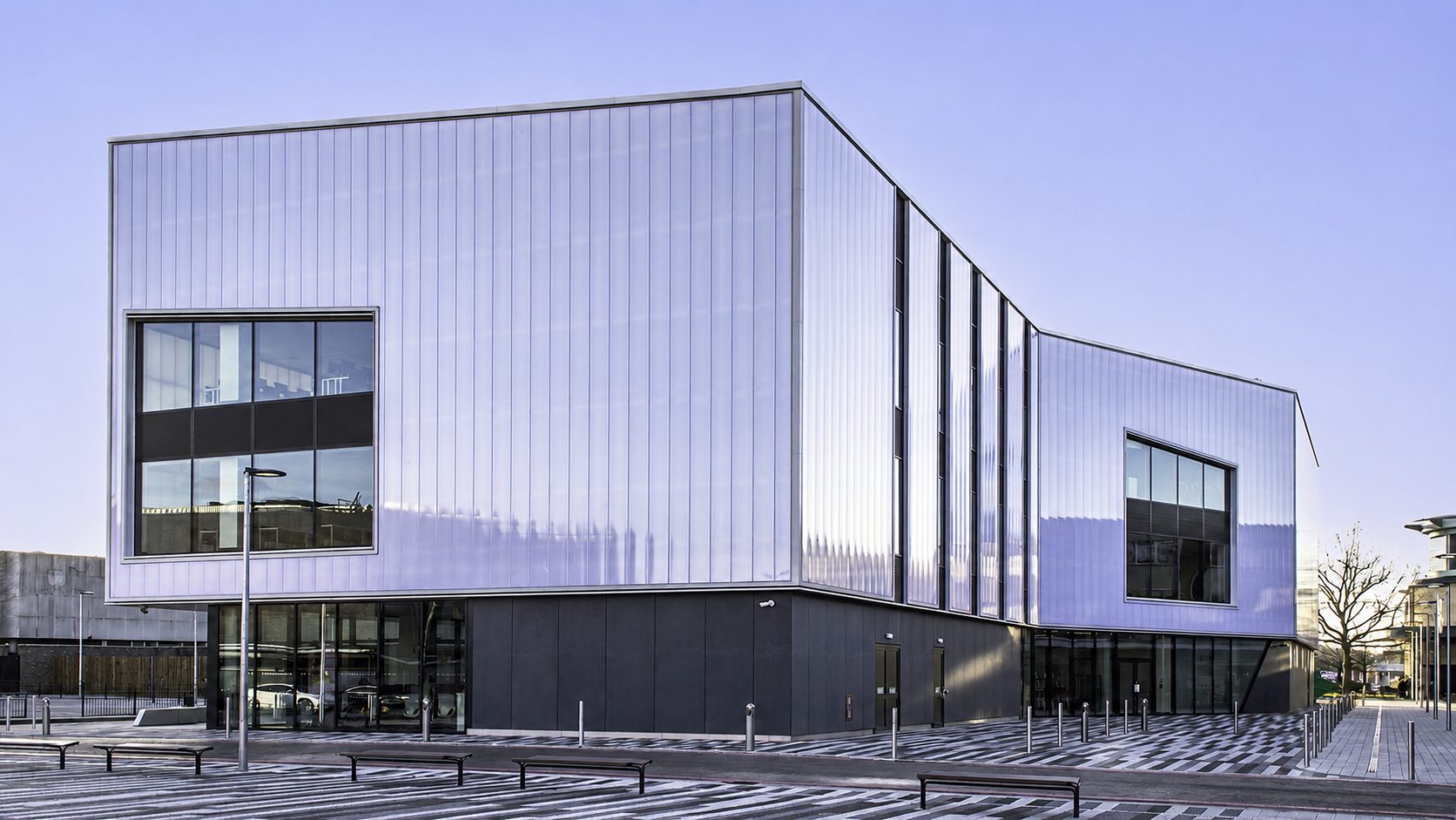 South Essex College's Centre for Digital Technologies at dusk, its folded pale cladding and full-height glazing at the building's leading corner