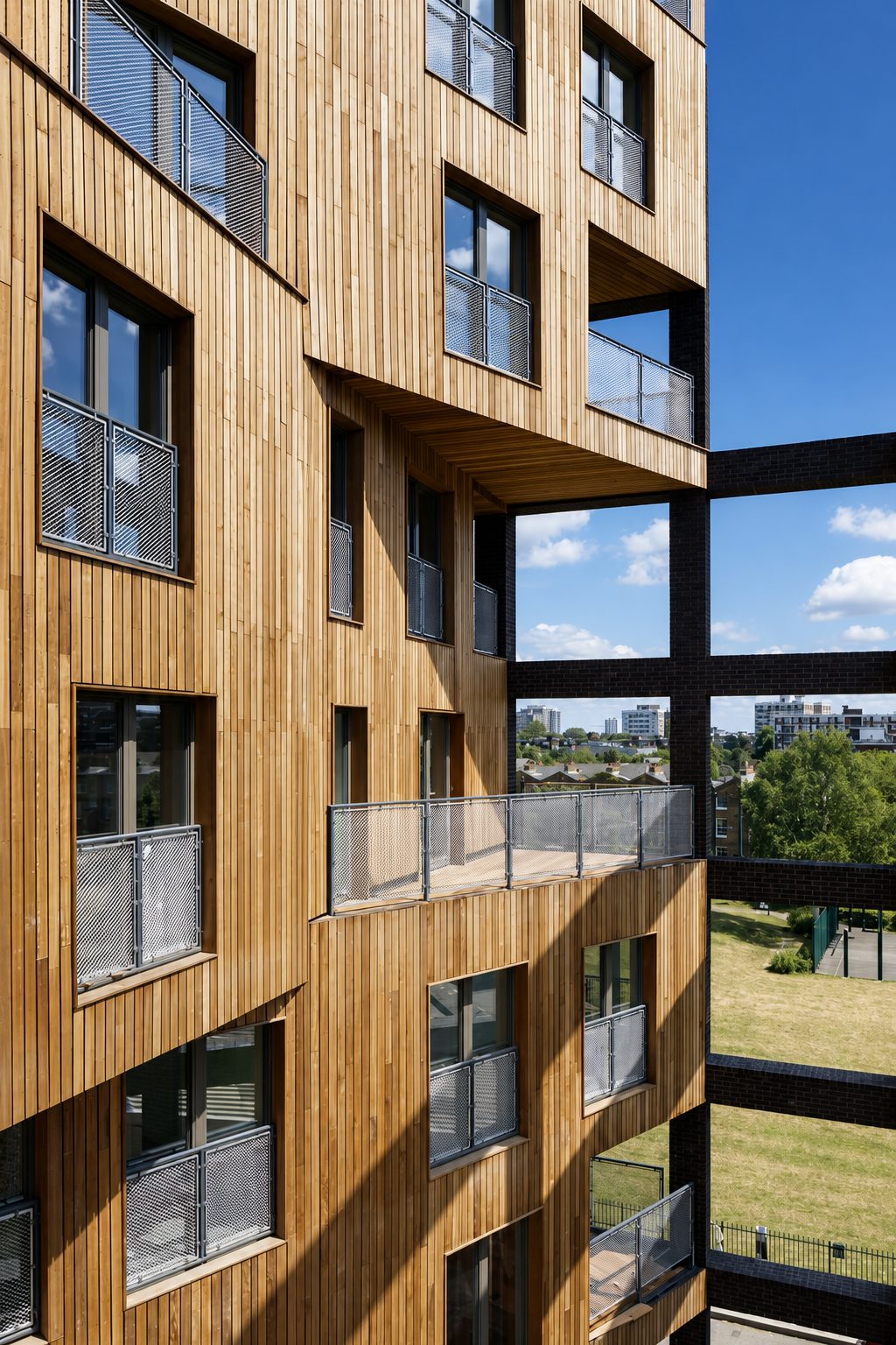 Tight upward view of The Cube's cedar-clad balconies against a blue sky corner