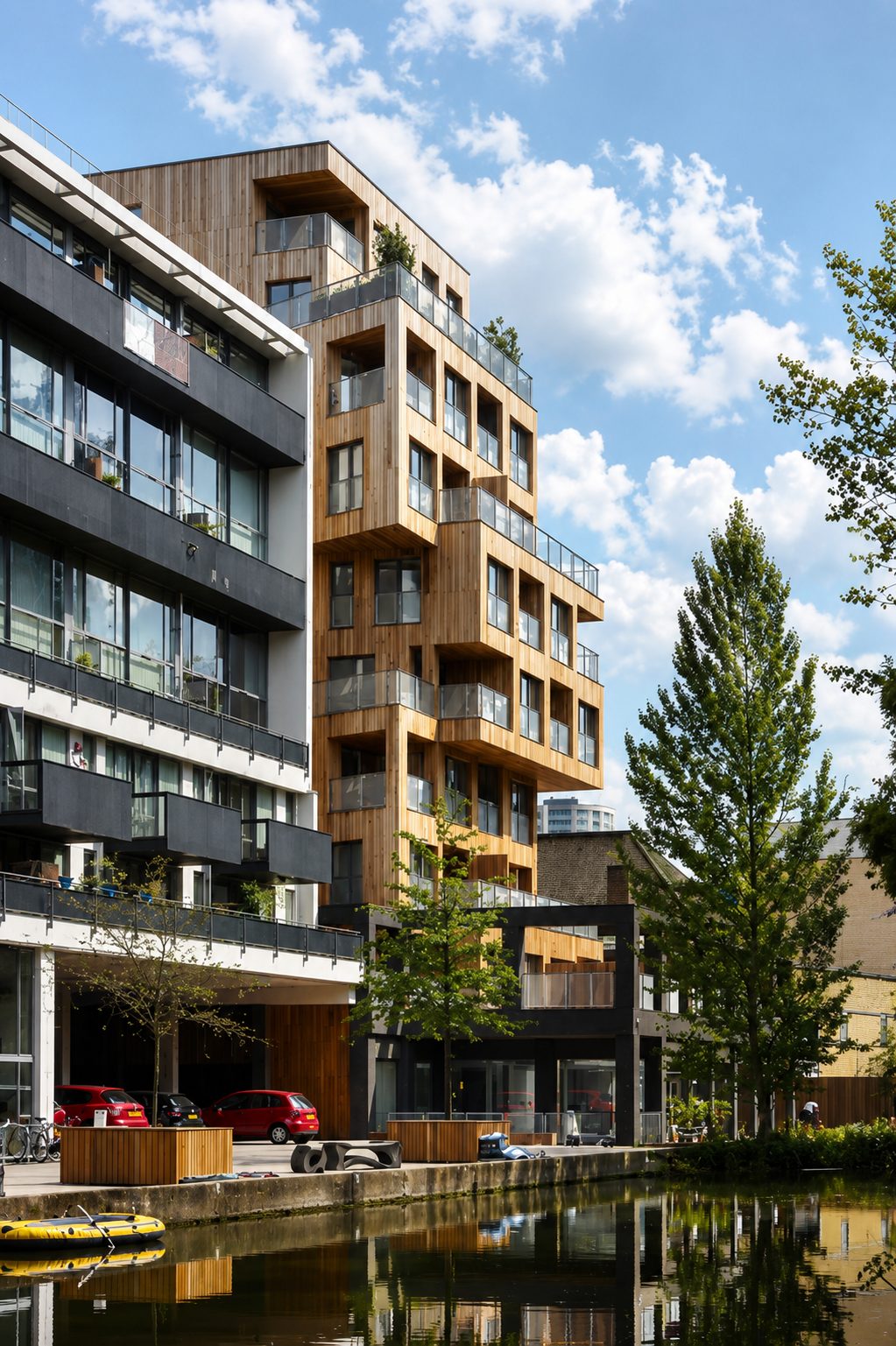 The Cube's cedar-clad wing reflected in Regent's Canal, beside a moored boat and the towpath