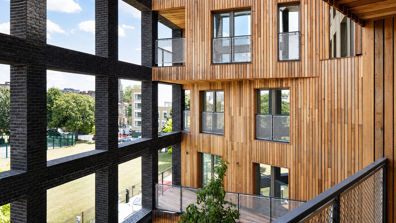 The Cube's cedar-clad courtyard elevation and mesh-balustraded balconies in the building's original form