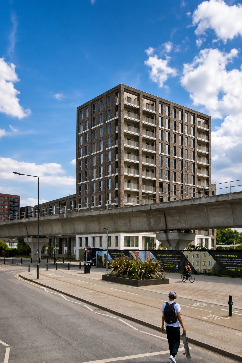 The Refinery's brick tower seen from street level beneath the Docklands Light Railway viaduct in West Silvertown