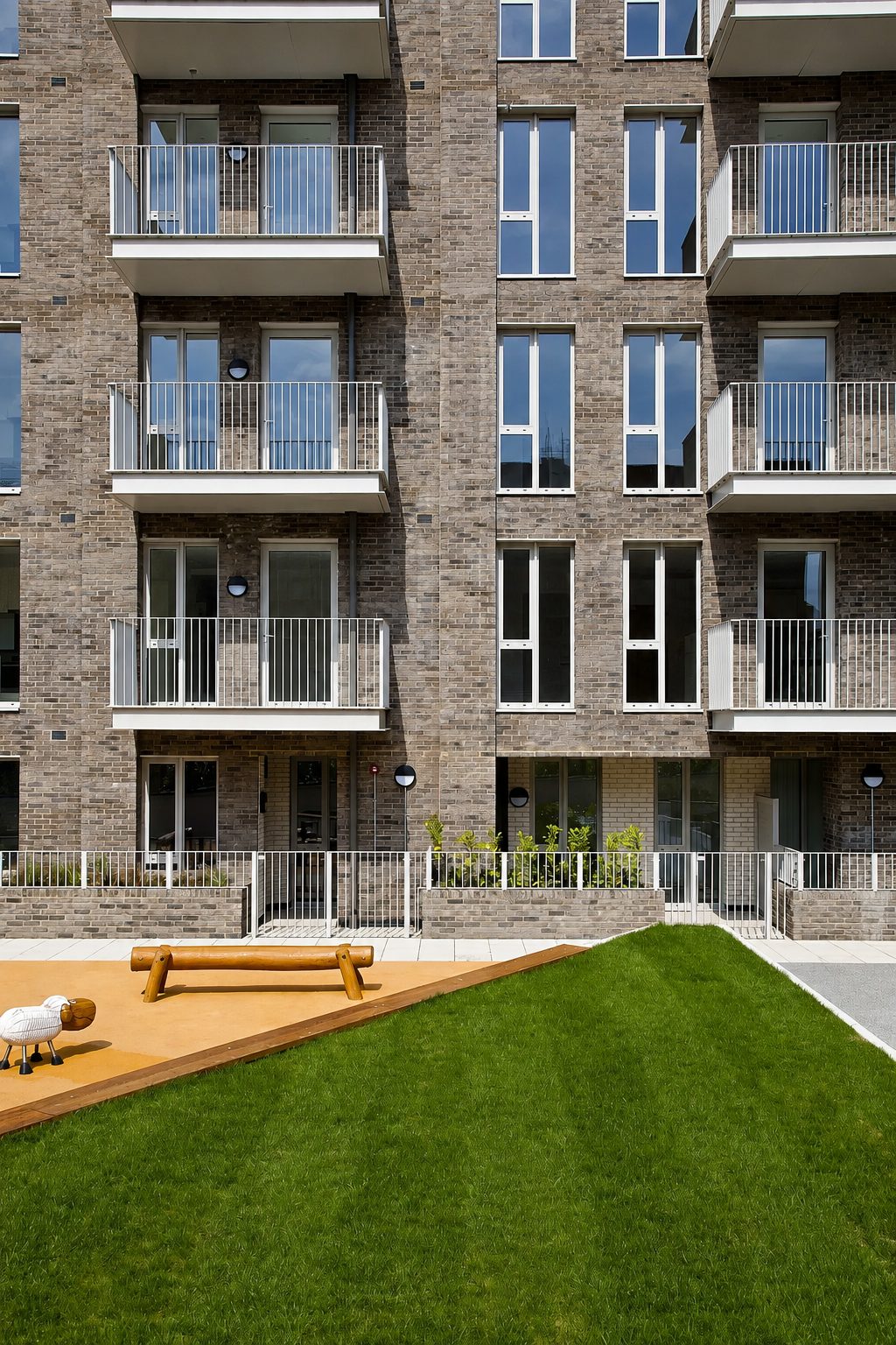 Closer view of The Refinery's podium garden lawn and timber play area, balconies rising above