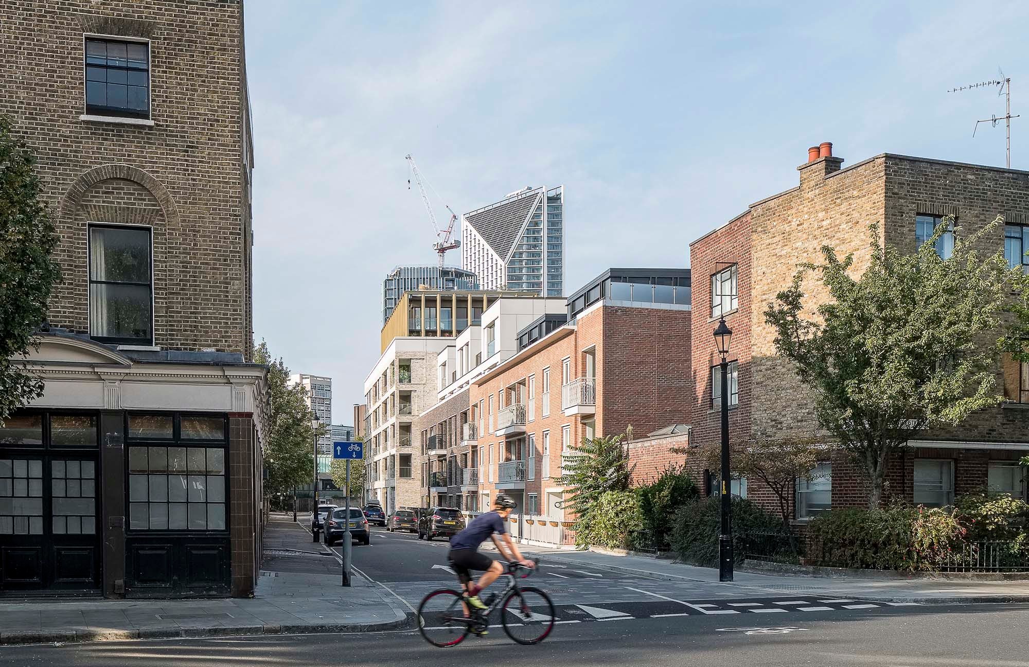 Trilogy seen from the street on Harper Road, its brick blocks stepping down beside the older terraced housing with the Shard beyond