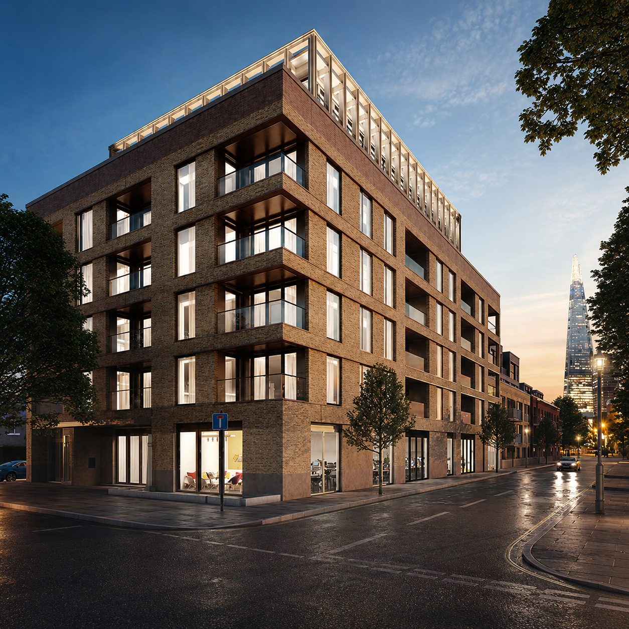 Another corner of Trilogy at dusk, its ground-floor units lit from within with the Shard beyond