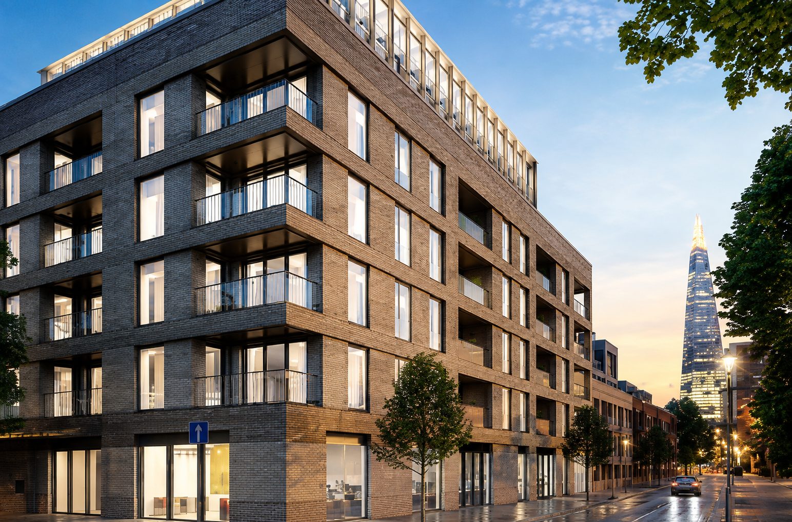 Trilogy's corner block on Harper Road at dusk, lit balconies above street level with the Shard visible along the road
